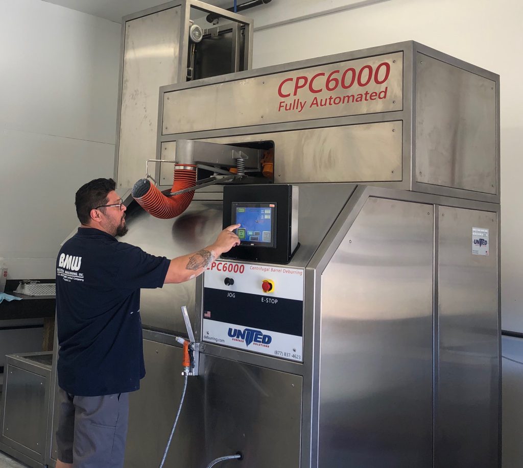Machinist operating CPC6000 Deburring Machine by United Surface Solutions