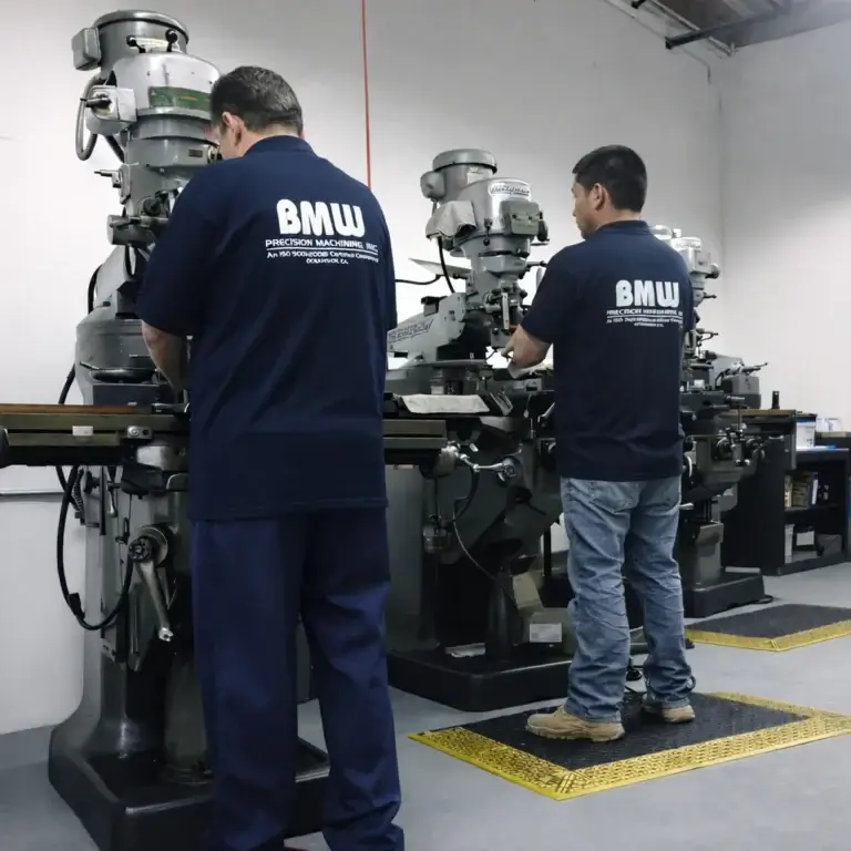 Two professional CNC machinists operating precision manufacturing equipment inside our Oceanside, California facility.